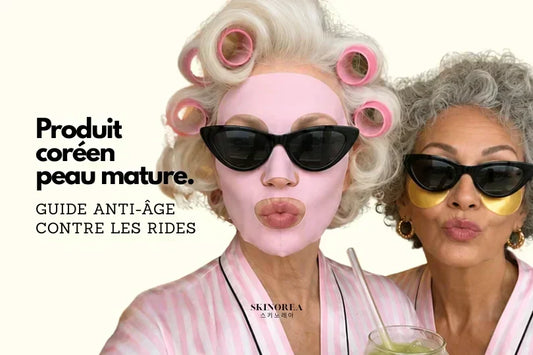 Deux femmes aux cheveux gris et blancs portant des masques tissu et des patches contour des yeux dorés, en peignoir rayé rose — soin coréen anti-rides pour peau mature, guide SKINOREA