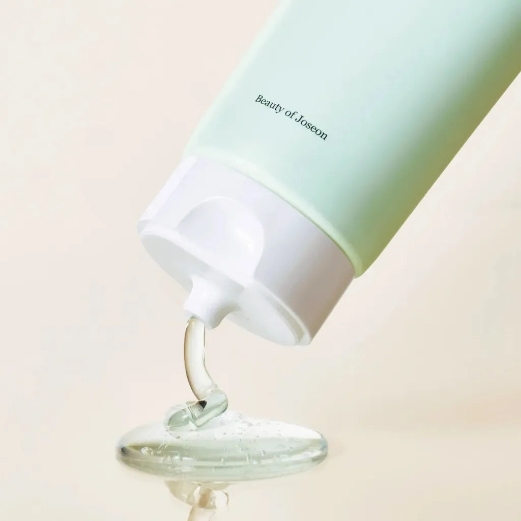 Beauty of Joseon Green Plum Refreshing Cleanser 100ml  - Un produit de soin du visage écologique en train d'être pressé sur une surface en verre, portant la marque Beauty of Joseon - SKINOREA K-beauty France Paris